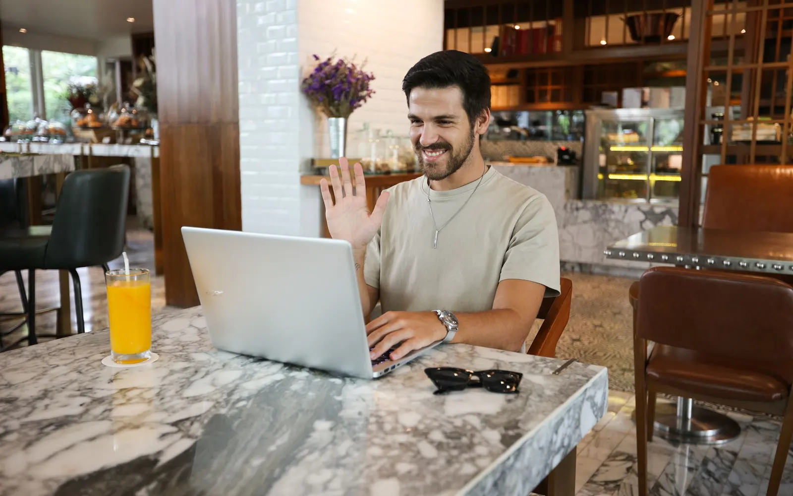 Business owner happily updating their own website from a laptop at a cafe